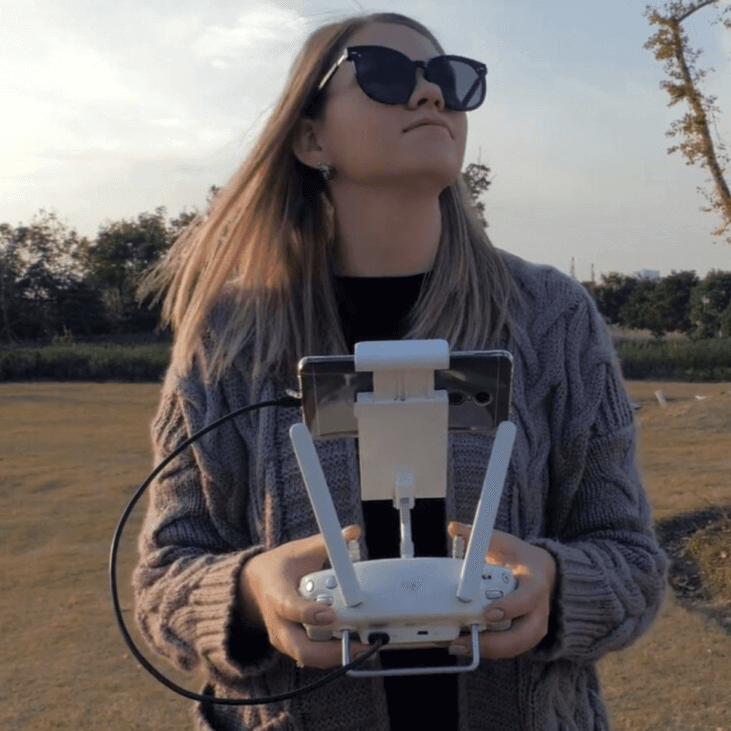 A woman using controls to fly a drone